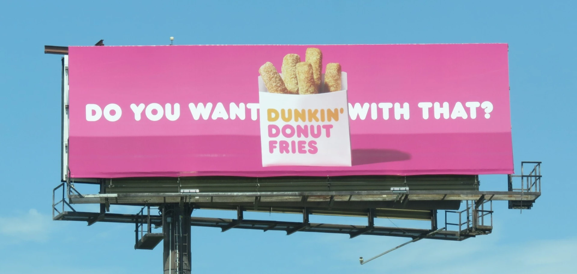 Dunkin' Donut Fries billboard with bold pink creative against a blue sky