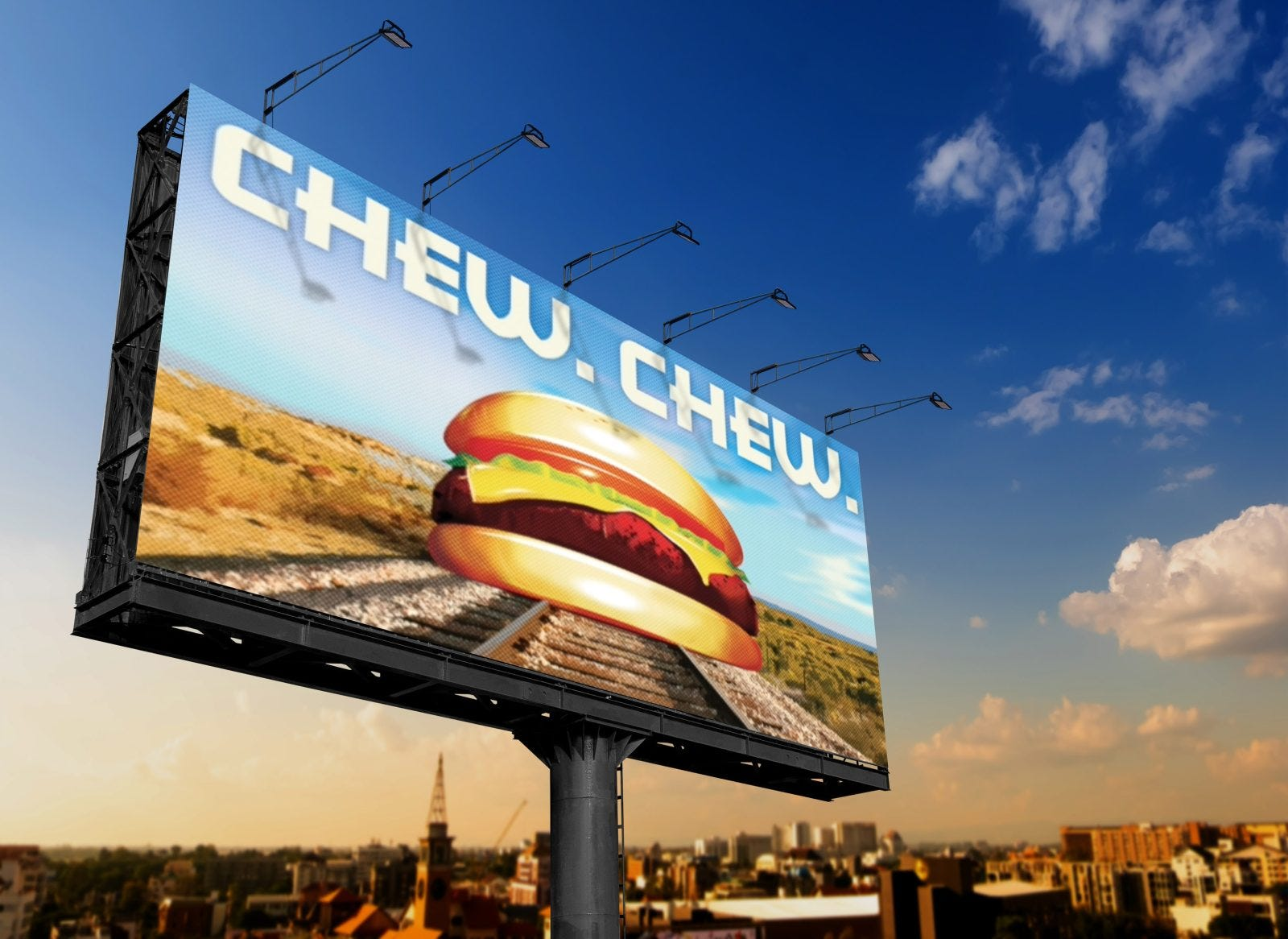 Large roadside billboard advertising a burger against a blue sky above a city skyline